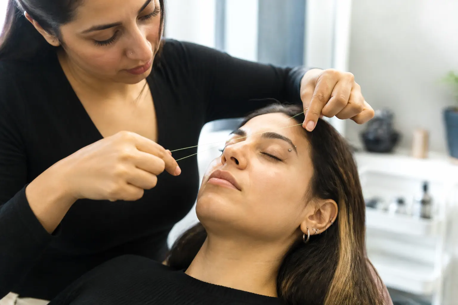 Editorial cover photograph about eyebrow threading with a brow piercing